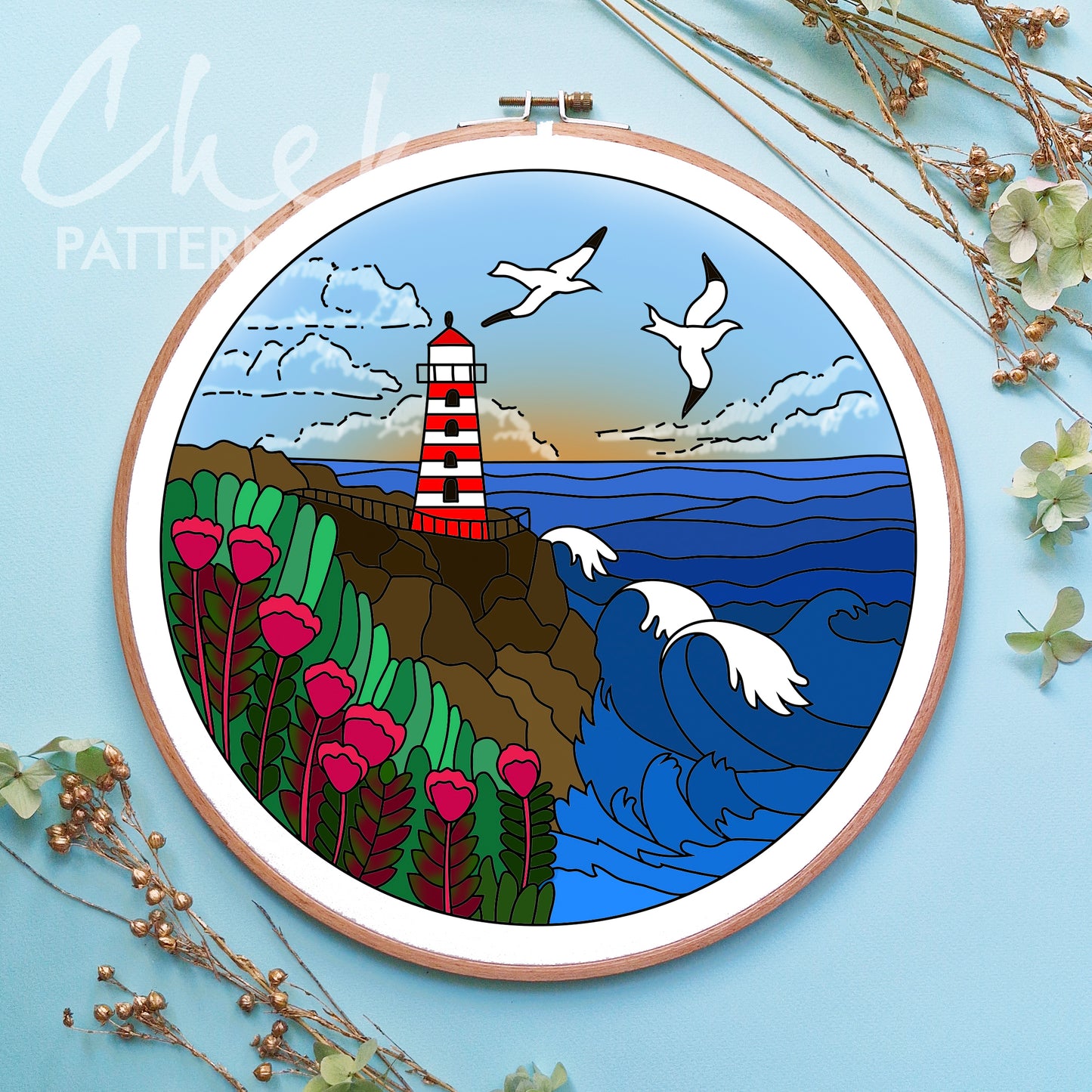 Embroidery hoop with a lighthouse and seagull design on a blue background