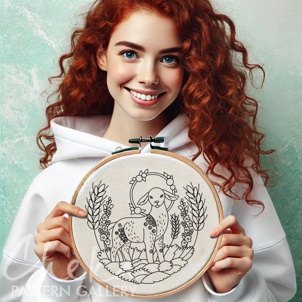 Woman holding a embroidery hoop with a design of a lamb and flowers.