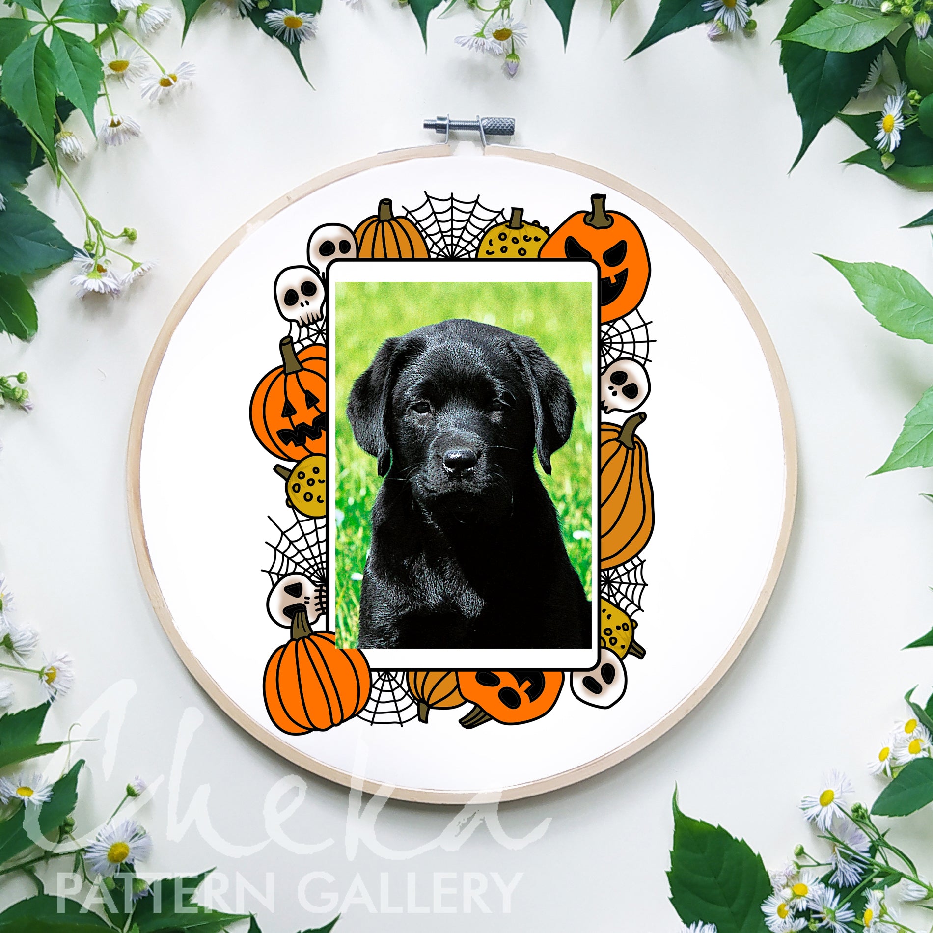 Black dog in a Halloween-themed hoop with pumpkins and ghosts on a white background.
