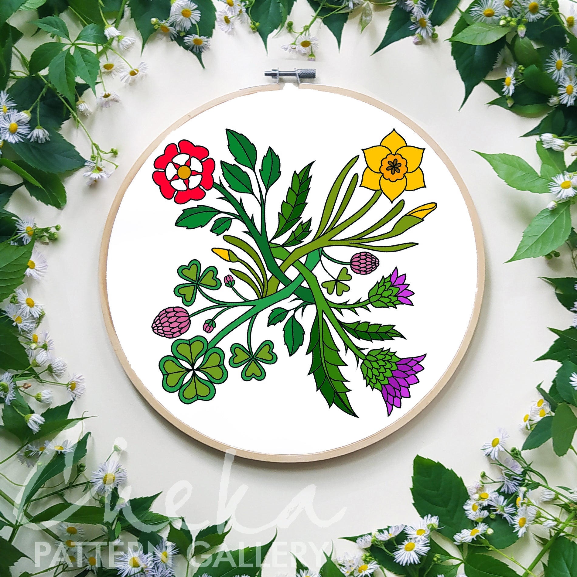 Embroidery hoop with floral design surrounded by green leaves and flowers on a white background