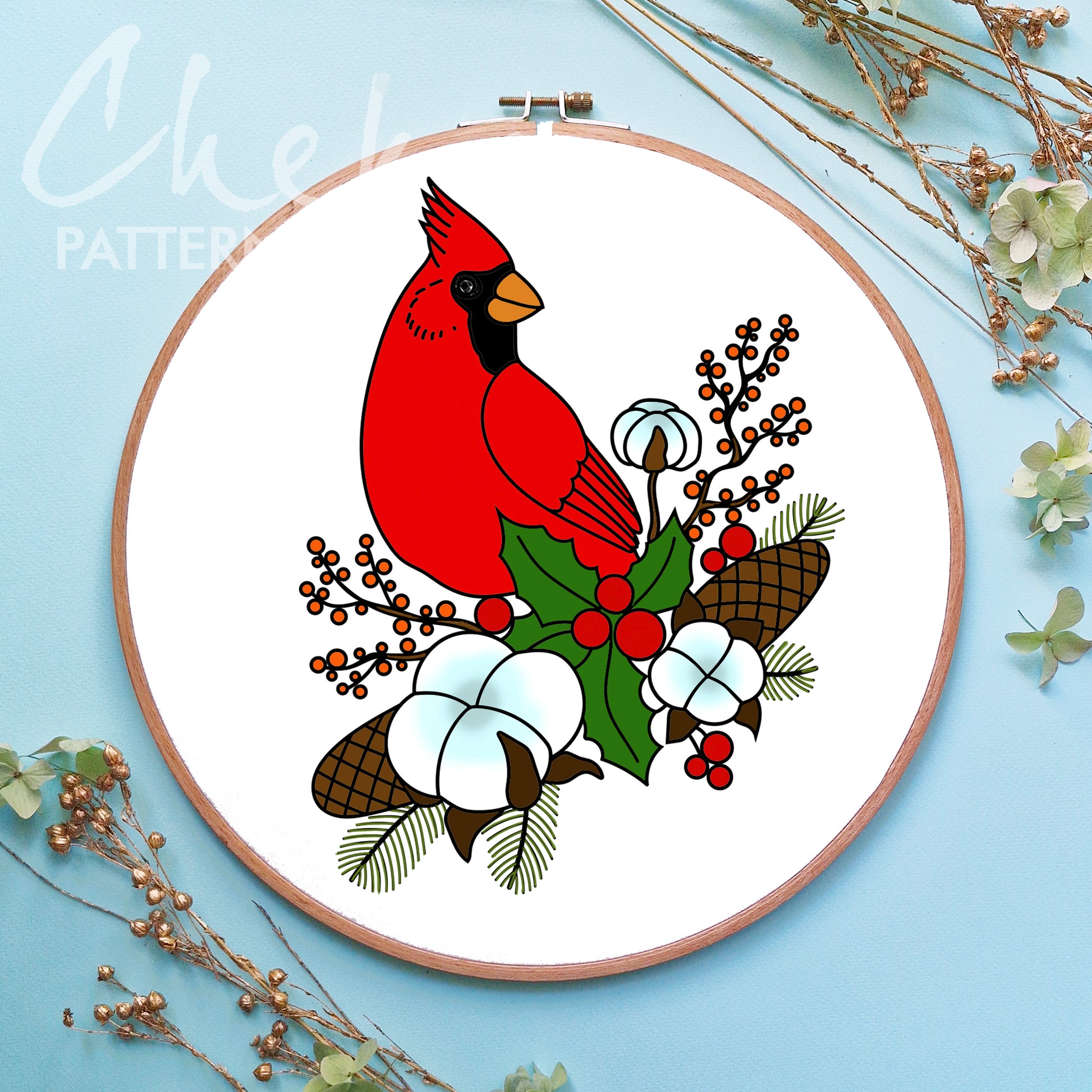 Embroidery hoop with a red cardinal design on a light blue background