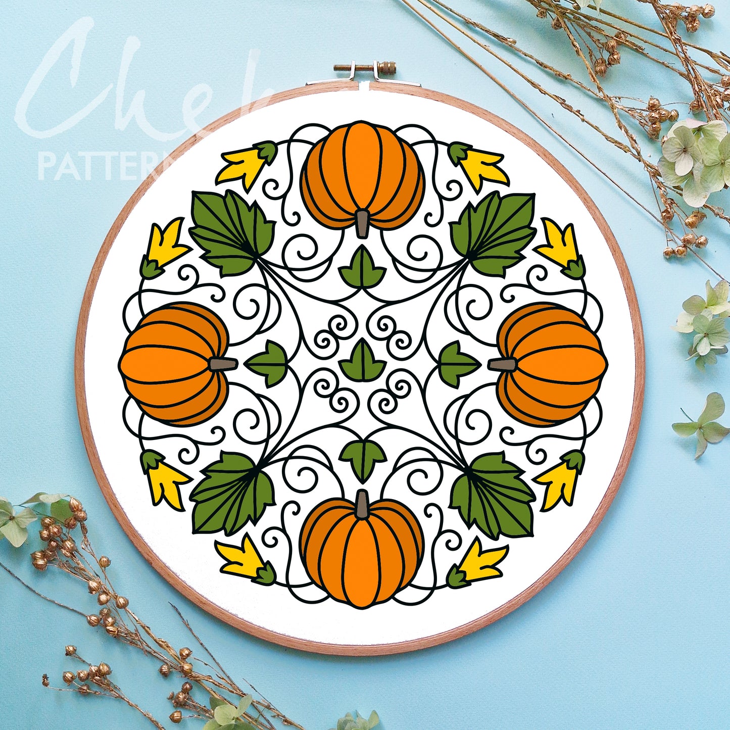 Embroidery hoop with pumpkin and leaf pattern on a blue background
