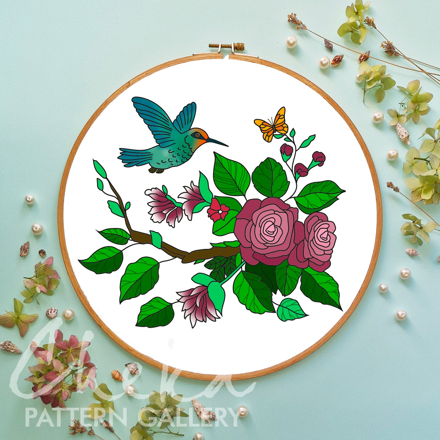Embroidery hoop with floral and bird design on a light blue background