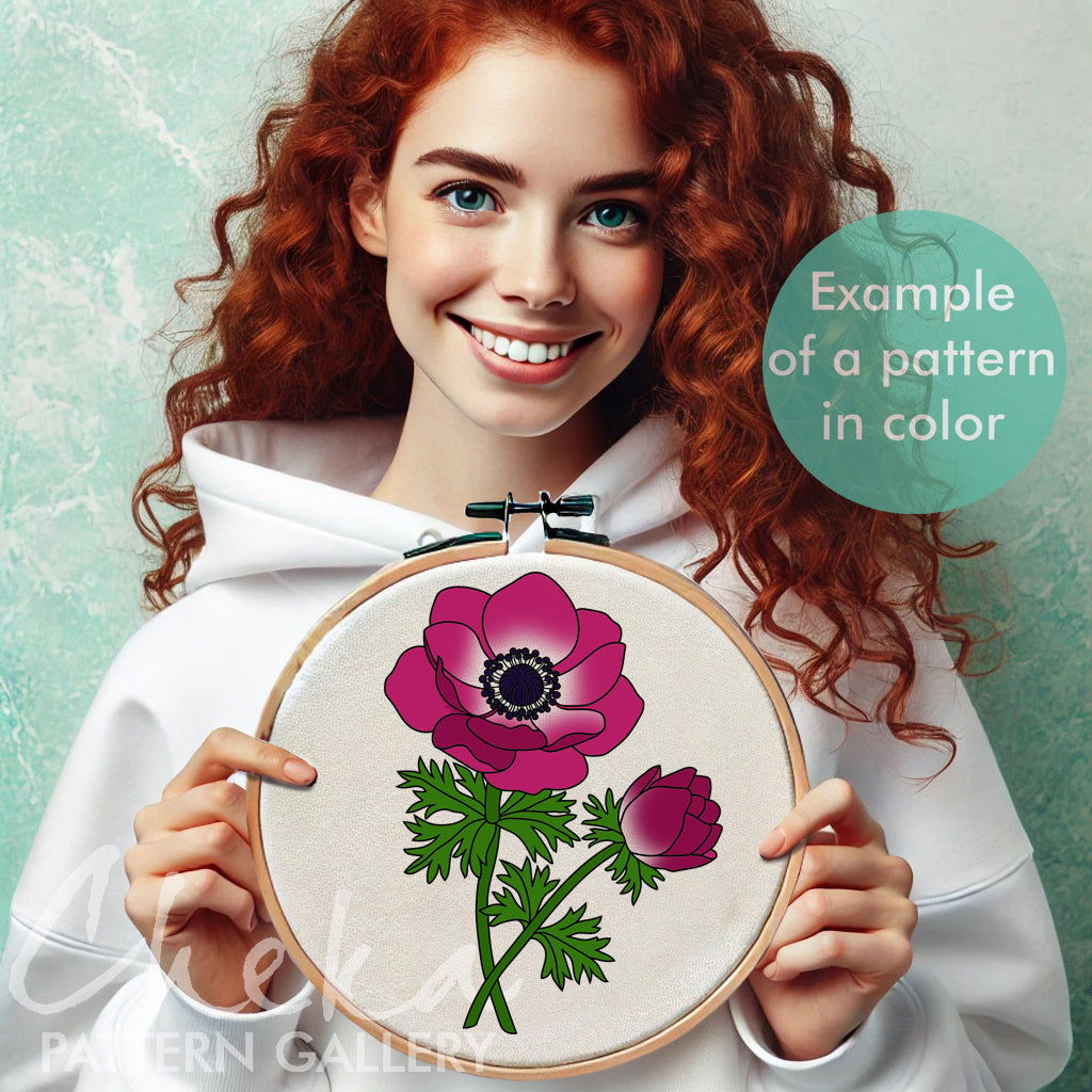 Woman holding a floral embroidery hoop with a pink flower design against a light green background.