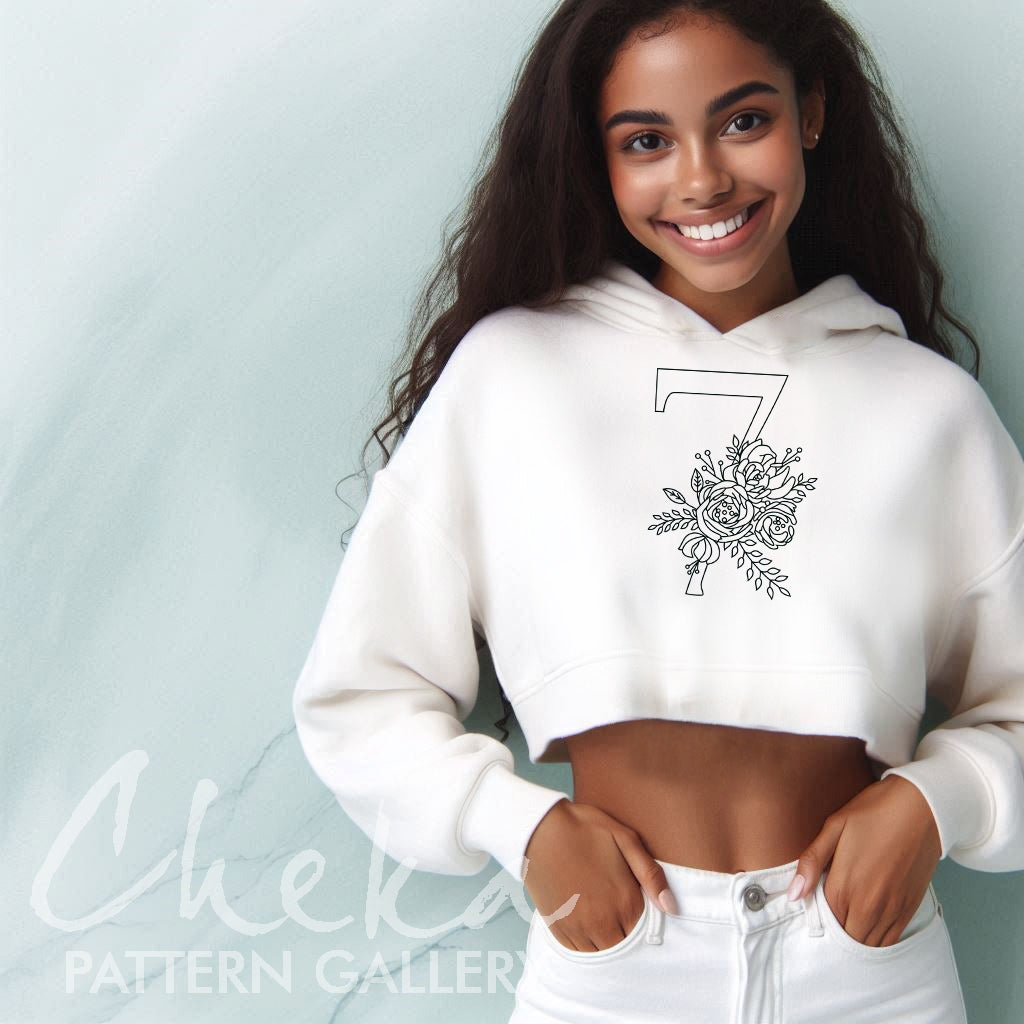 Woman wearing a white hoodie with a black floral design on a light blue background